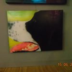 Porträt eines schwarz-weißen Hundes mit offenem Maul vor farbigem Hintergrund, mit Katze im Bild – ausgestellt am 15.06.2022.