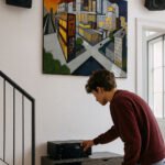 Stilisierte Stadtansicht mit leuchtenden Fenstern, surrealem Himmel und ALPHA-Schriftzug – geometrisches Nachtpanorama