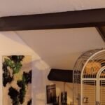 Abstraktes Gemälde auf Leinwand (57 x 87 cm) mit fließender Textur in Grün, Violett und Schwarz auf hellem Hintergrund. Unter Lack versiegelt, mit gezieltem Materialbruch am Rand. Die marmorierte Struktur erinnert an natürliche Formen und erzeugt Tiefe und Bewegung.